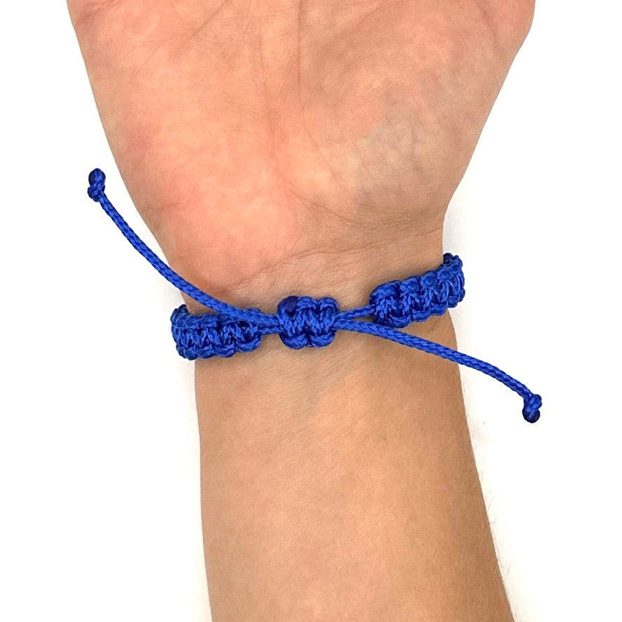 Handgelenks Rückseite mit blauem Makramee Armband. Man sieht den Schiebeknoten, zum einfachen an und ausziehen des Armbandes