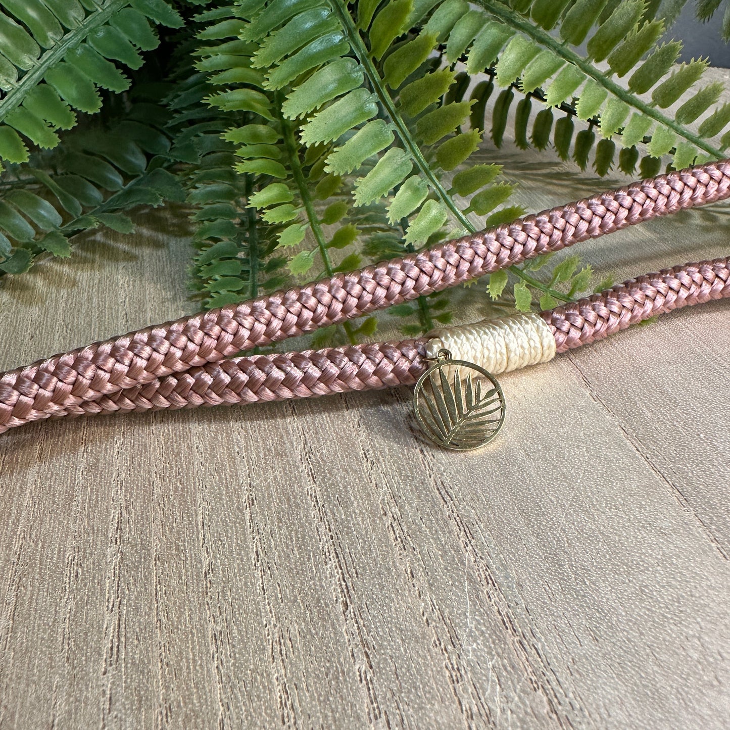 Detailaufnahme eines Wunsch-Charms an Segeltau Handykette in rosé/rostbraun 