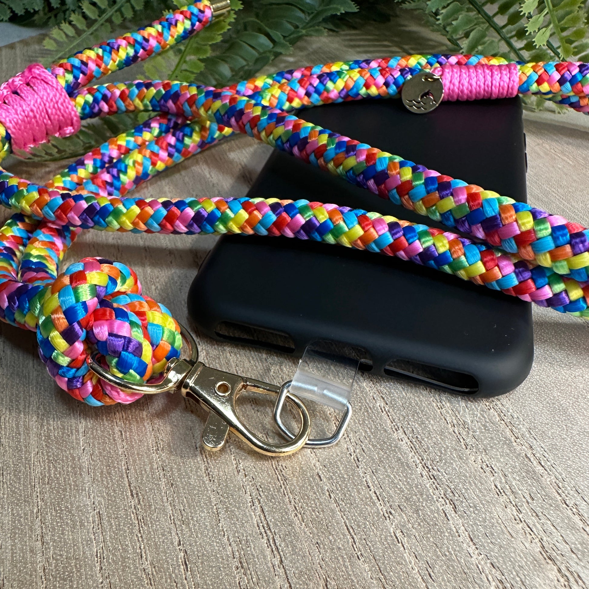 Nahaufnahme goldfarbener Karabiner an bunter Handykette Bubblegum