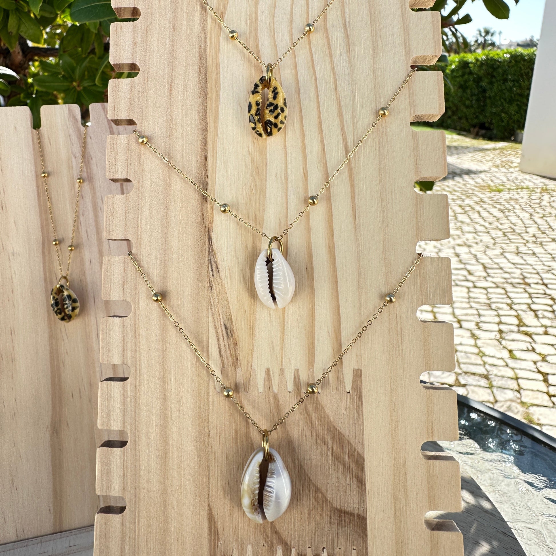 Alle 3 Kaurimuschel-Halsketten in Nahaufnahme – weiß, leo-design und natur 