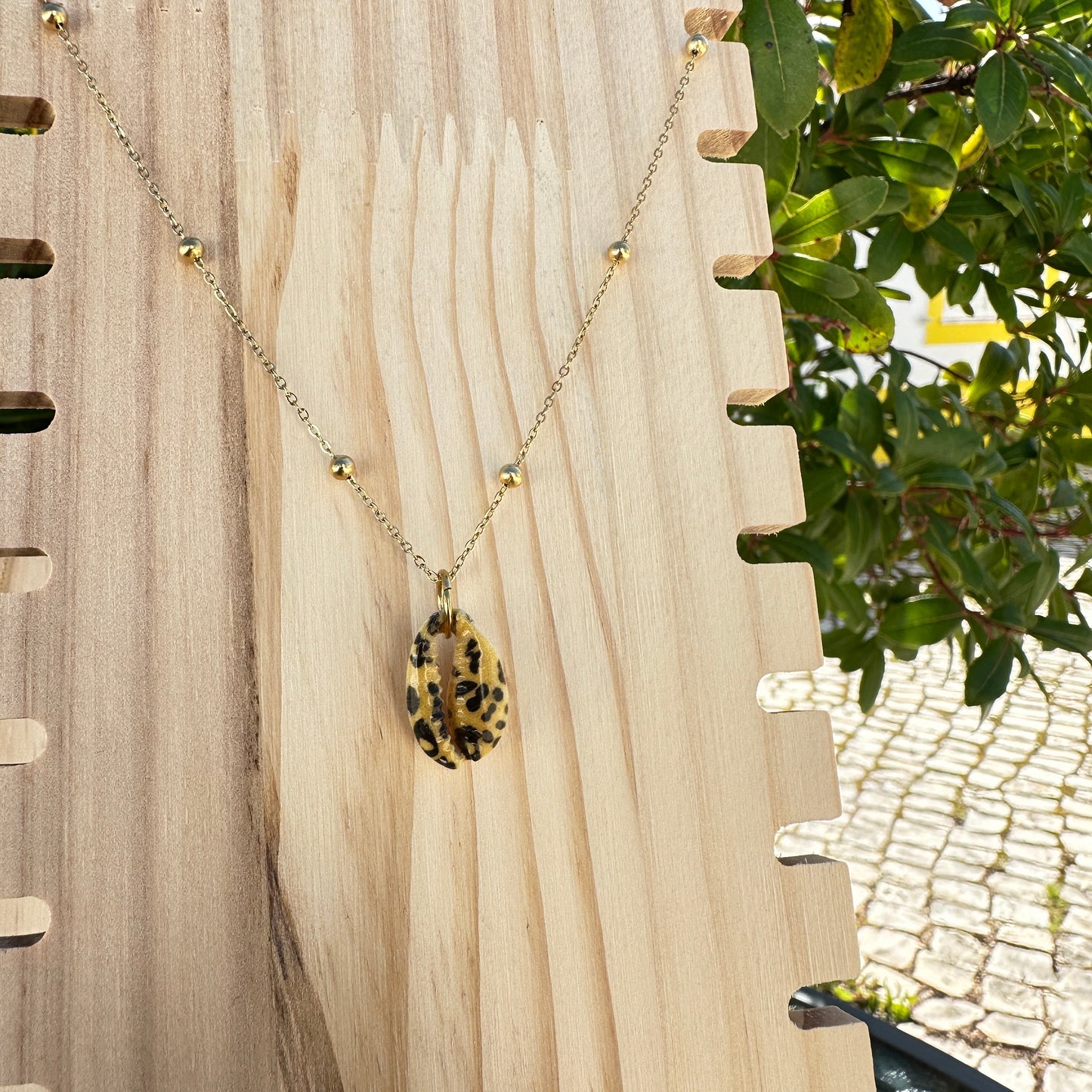 Leo-Kaurimuschel-Halskette an Holzdisplay 