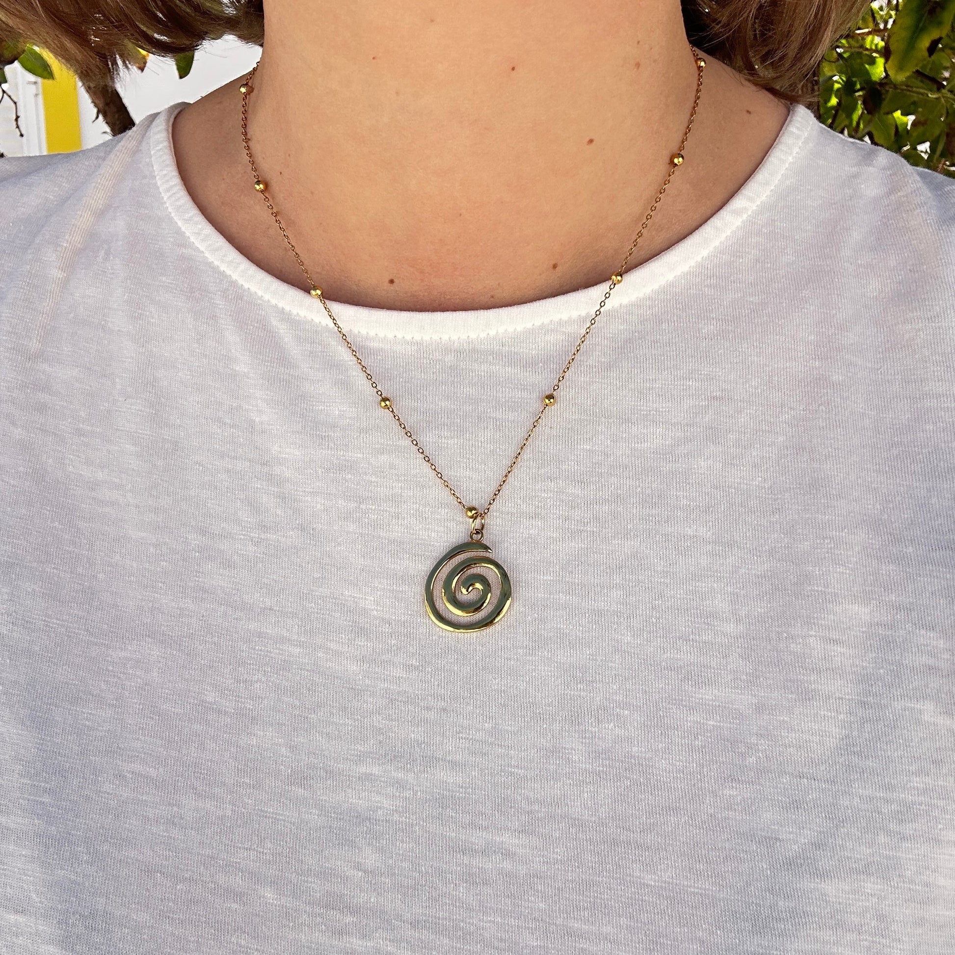 Goldene Halskette mit Spiral-Anhänger aus Edelstahl, getragen am Hals